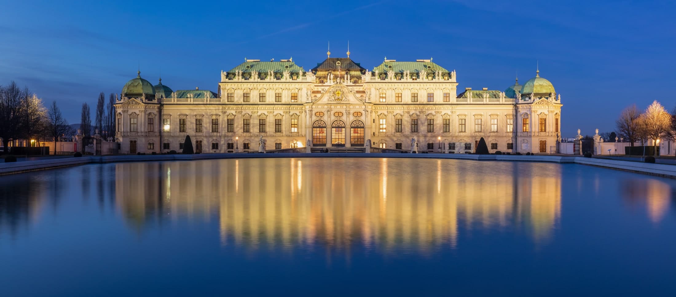 Upper Belvedere Palace reflected in its pool at dusk